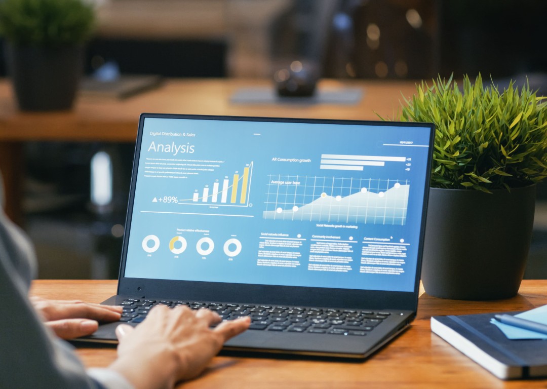 laptop on desk showing graphs