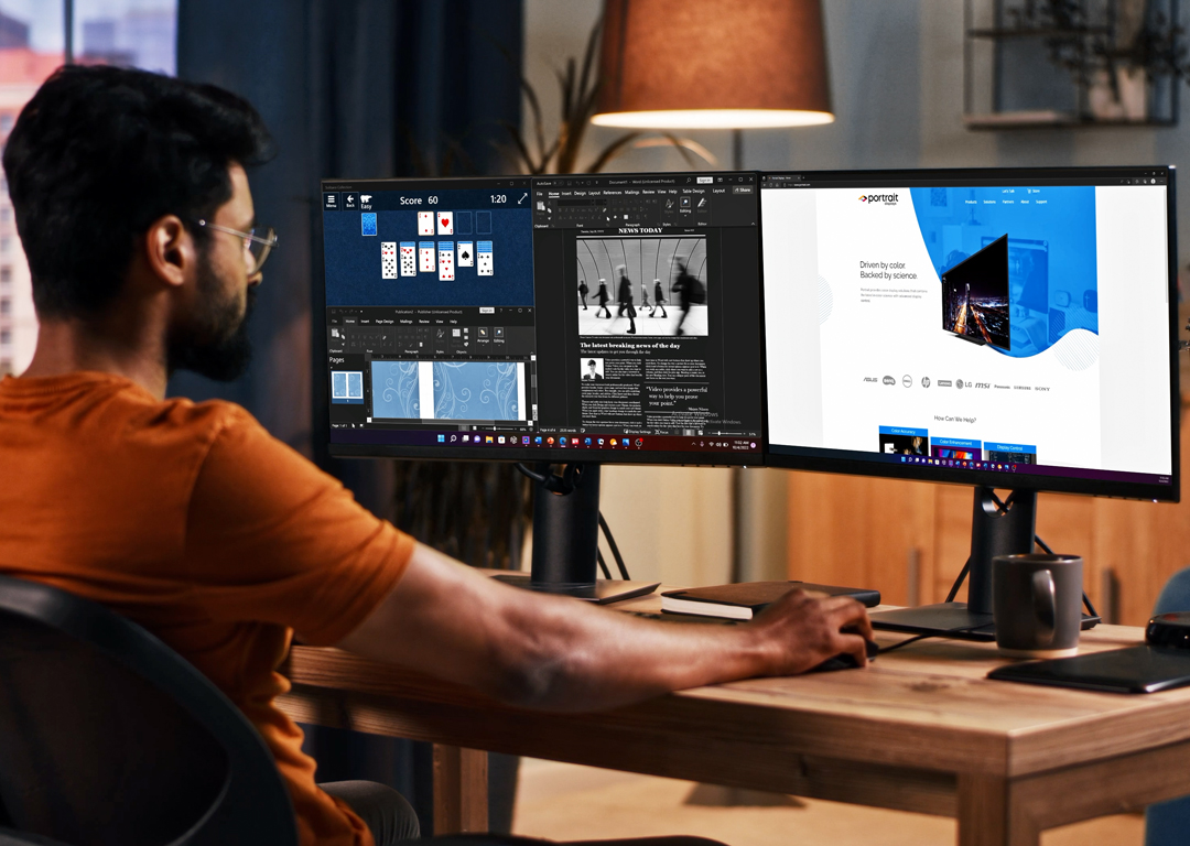 person on dual monitor with multiple windows